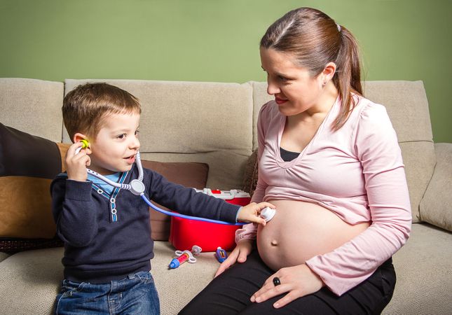 Child doctor examining his pregnant mother