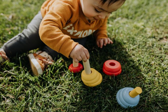 Cute child playing with toys in the grass