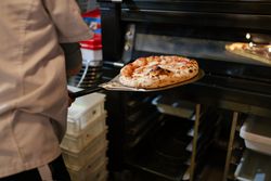 Pizza on a shovel fresh from the oven