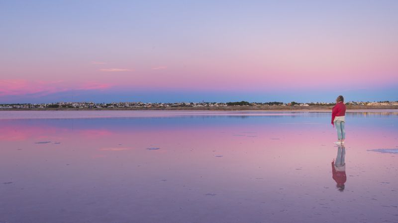 Woman admiring beautiful sky on empty beach