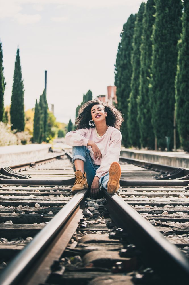 Black woman laughing in the tracks of a train