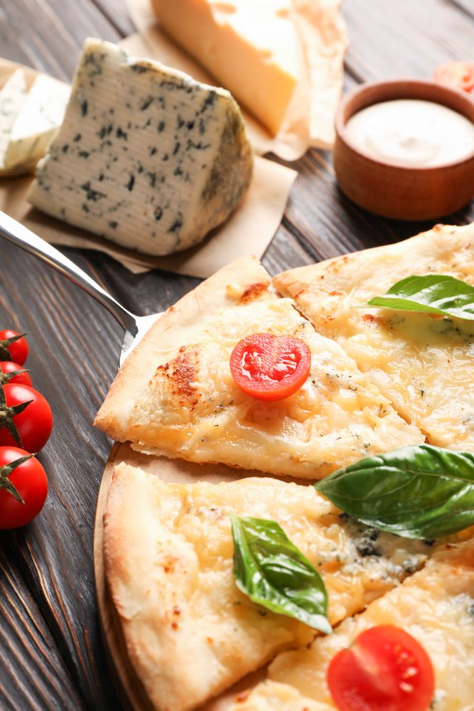 Cheese pizza and ingredients on wooden background, closeup