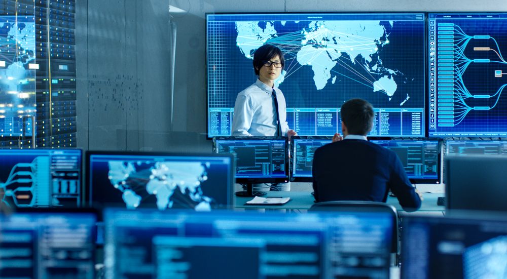 In the System Control Room Manager Holds a Briefing for His Staff Member.