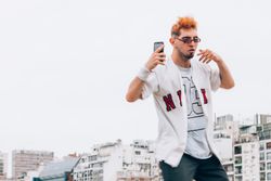 Contemporary male in casual trendy taking selfie