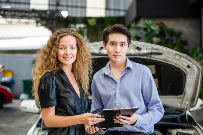 Asian car salesman with female client
