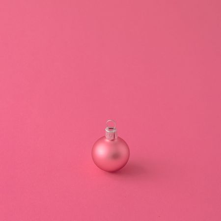 Pink Christmas bauble decoration on pink background