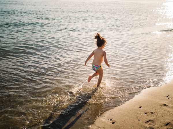 Anonymous girl running on seaside