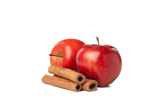 Side view of two apples and cinnamon sticks