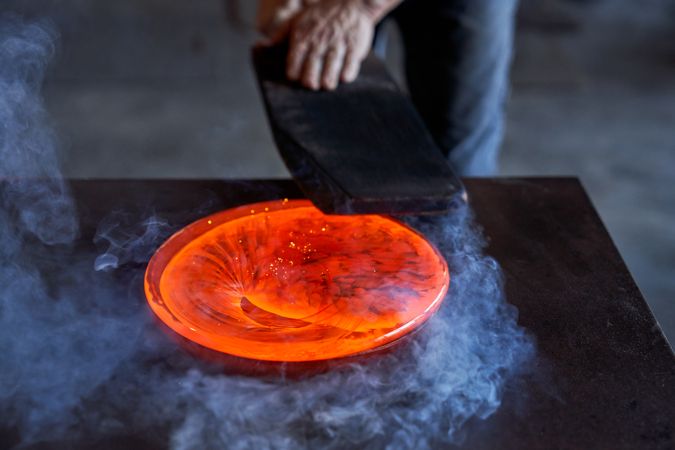 Male master working with hot orange glass