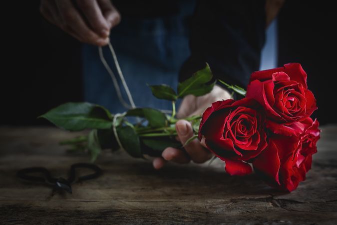 Unrecognizable woman making a bouquet of red roses