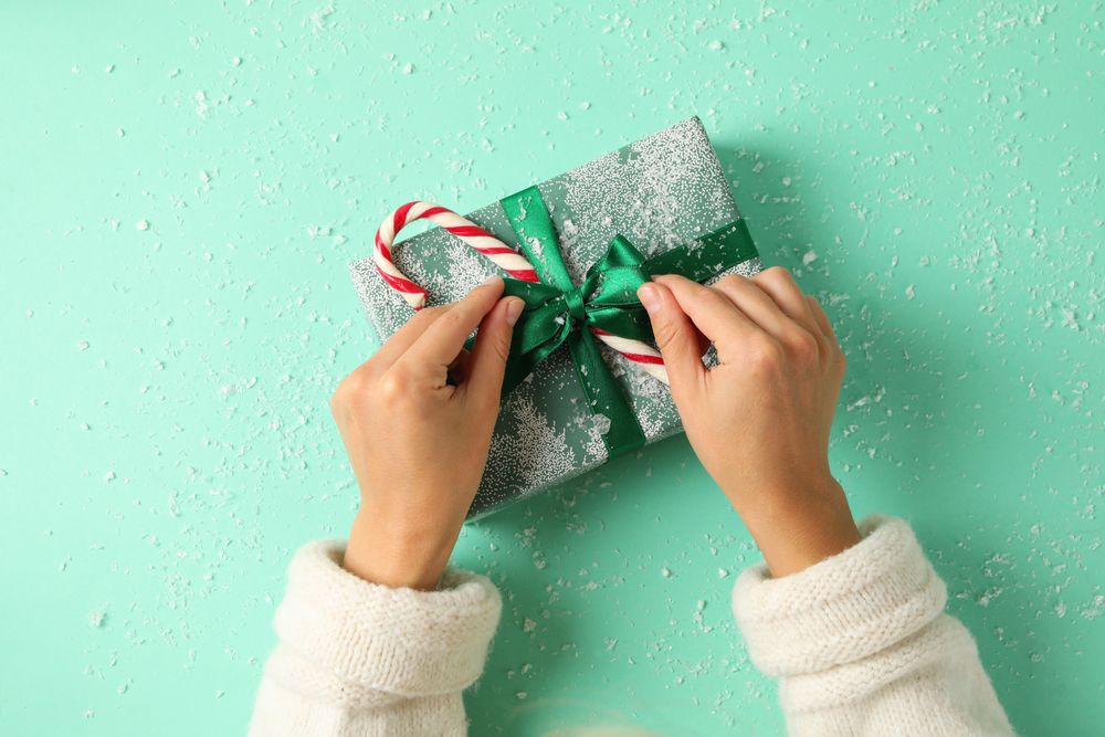 Female hands open the gift box on mint background