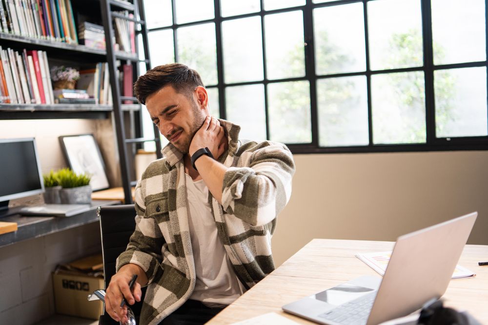 Man in office with a crank in his neck