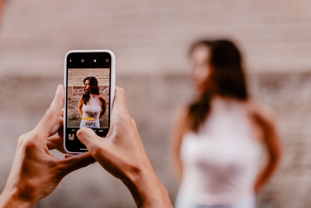 Faceless male taking photo of brunette woman