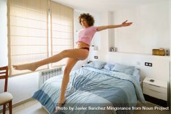 Woman in pajamas falling back onto her comfortable bed 0Lm3r5