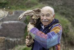 Mature man breaking stone formation