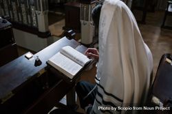 Jewish man wearing tallit reading the Holy Book in the synagogue 42xKy0
