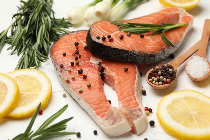 Composition with salmon meat and spices on plain background, close up