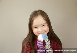 Young girl smiling and playing with socks on her hands 0PELN5