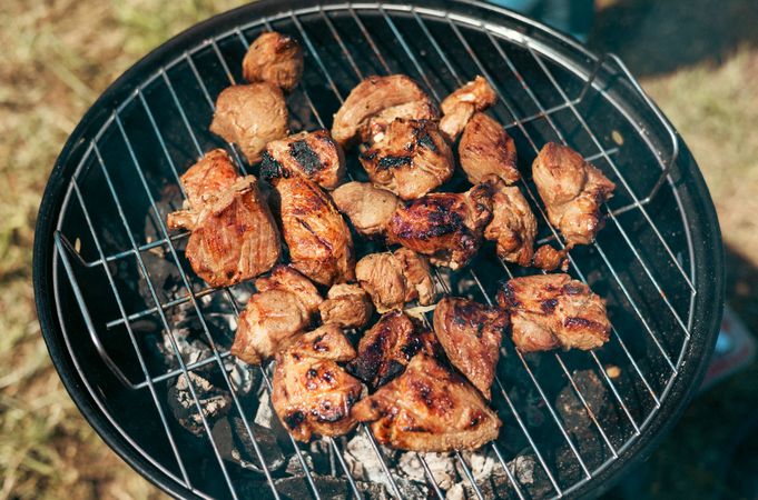 Meat is fried on a campfire, barbecue in nature. Pickled meat is cooked on coals, Grilled BBQ.