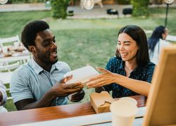 Diverse couple receiving takeaway order in food truck