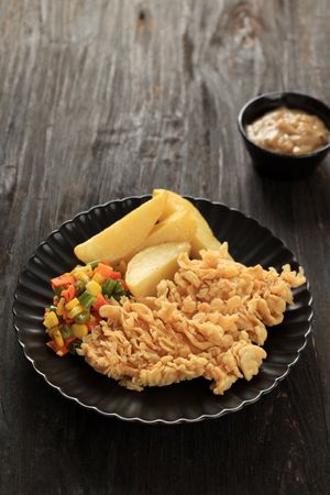 Crispy Chicken FIllet Steak with Potato Wedges, Sauted Mixed Vegetables, and Mushroom Sauce.