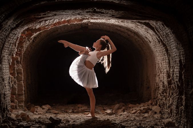 Young girl performing rhythmic gymnastics exercises outdoors