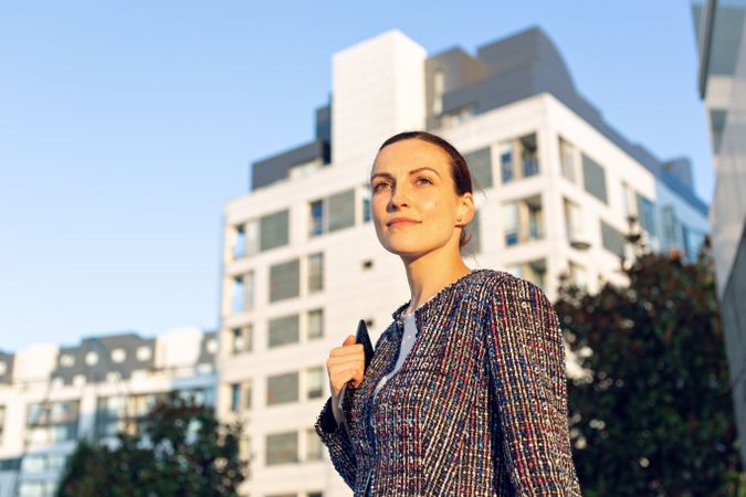 Serious businesswoman leaning on railing