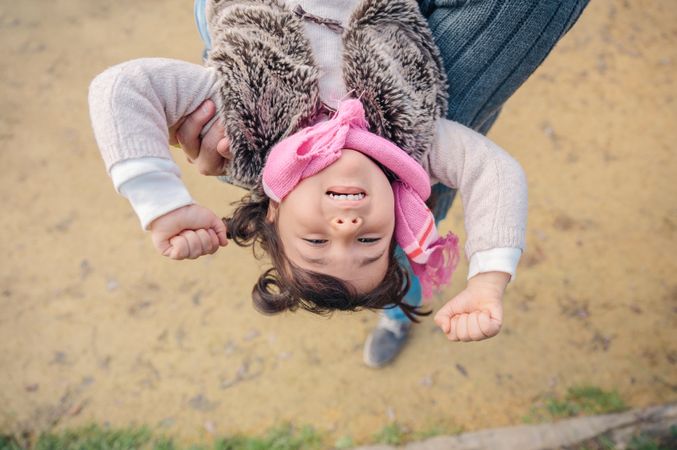 Child being held upside down outside
