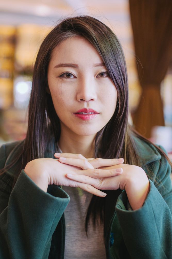 Portrait of young Asian woman looking at camera