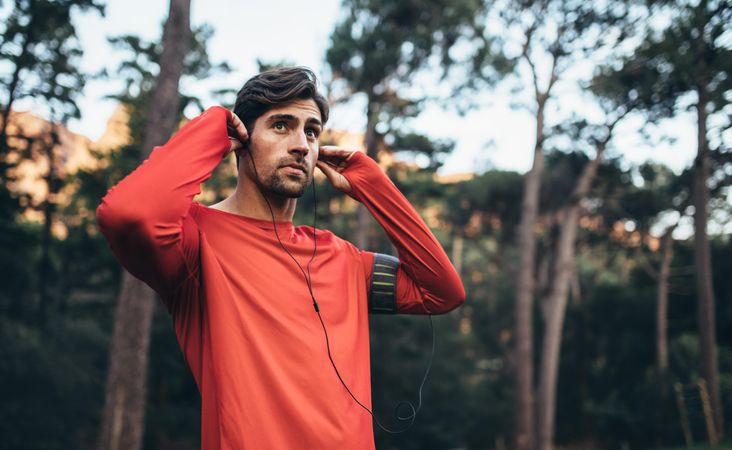 Male runner listening to music during morning jog