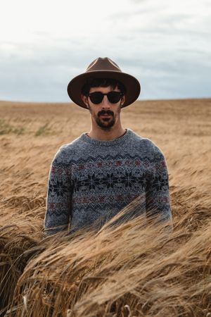 Man standing on dry field and looking at camera