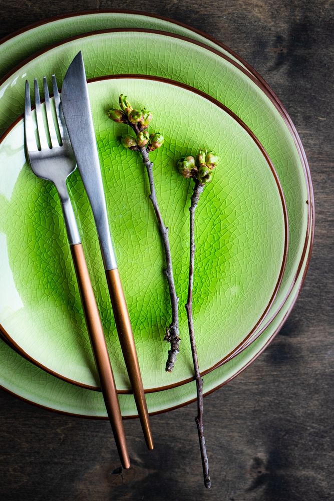 Top view of green plate table setting with cherry blossom