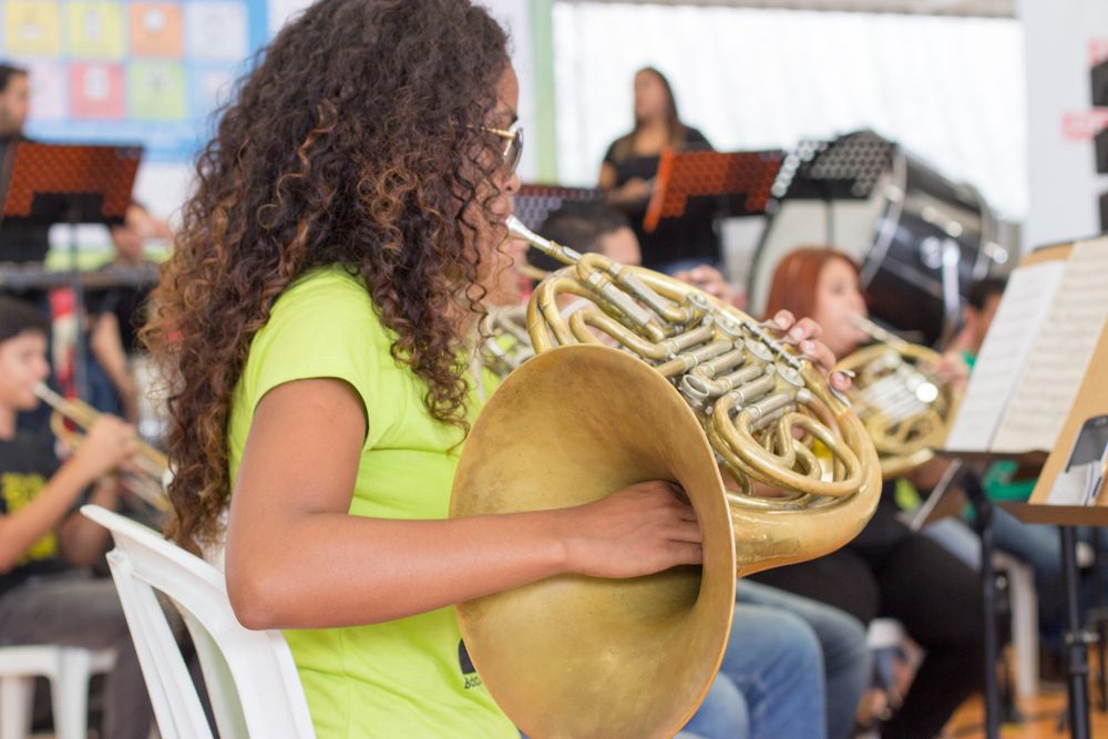 Girl with curly hair playing brass trumpet