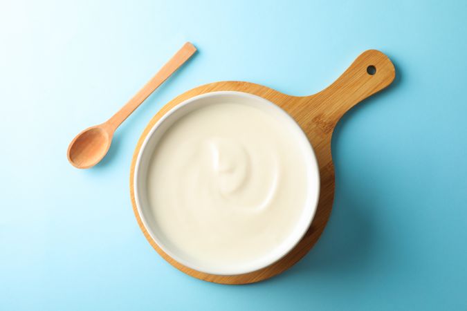 Composition with yogurt in bowl on color background