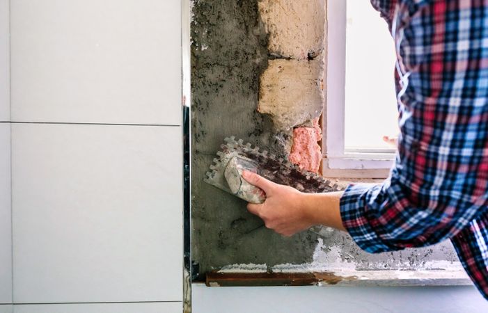 Female bricklayer leveling cement with a trowel