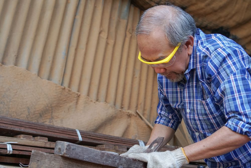 Asian woodworker working on a wooden panel in the shop