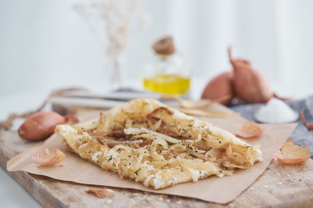 Appetizing onion tart on chopping board