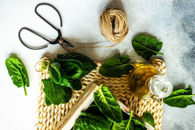 Top view of spinach leaves with oil on rattan placemat