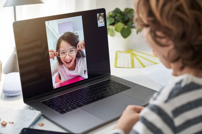 Boy video chatting with girl in eyeglasses