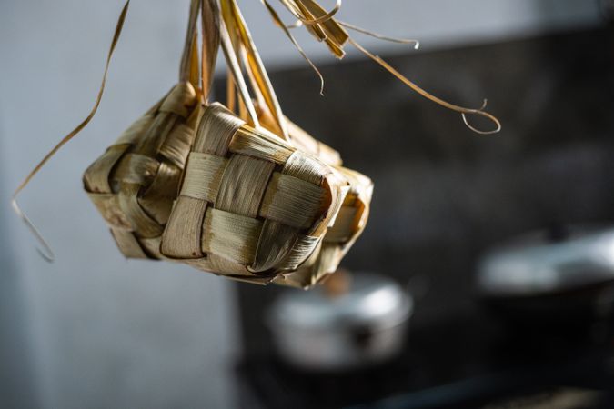Cooked ketupat hanging on a wooden rack to keep fresh and dry