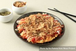 Plate of okonomiyaki served with chilli sauce and mayonnaise bxlkrb