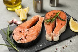 Composition with salmon meat and spices on gray background, close up