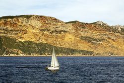 sailboat in sea and beautiful rocks