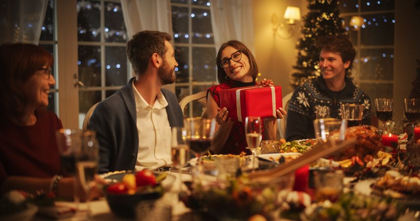 Multicultural Family Exchanging Gifts to Celebrate the Holiday. Portrait of a Young Woman Excited to Receive a Present.