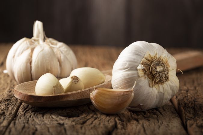 Garlic bulb and garlic cloves on the wooden table.