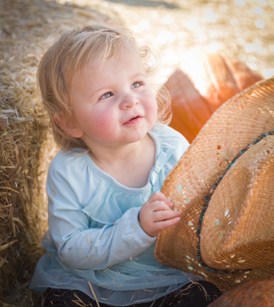 Adorable Baby Girl with Cowboy Hat at the Pumpkin Patch.