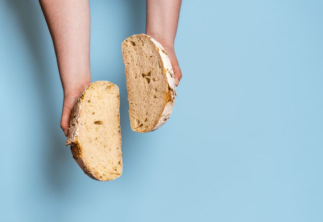 Sourdough bread sliced in two against a blue background