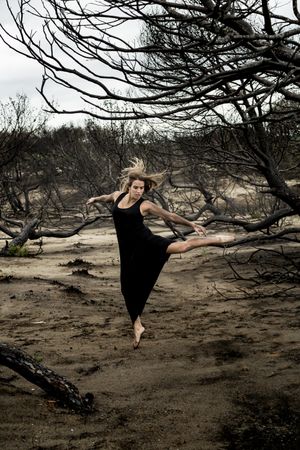 Woman dancing between dry trees