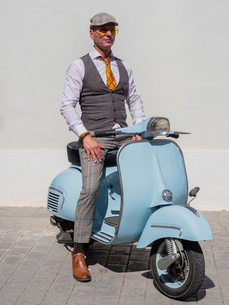 Trendy man sitting on vintage scooter