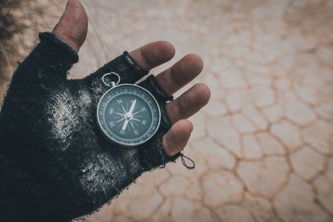 Compass in hand on dry desert area